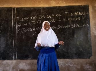 Photo of a female school student in front of a chalk board